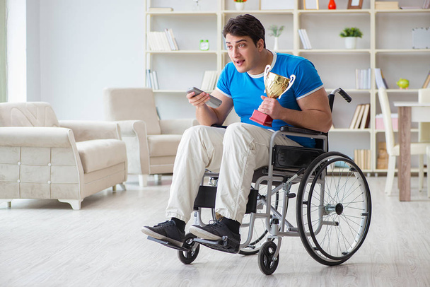 інвалідний чоловік дивиться спорт на телебаченні
 - Фото, зображення