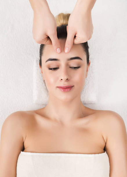 Mujer recibiendo masaje facial profesional en el salón de spa
 - Foto, Imagen