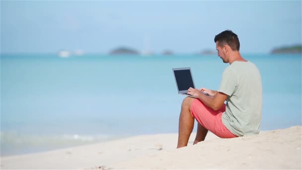 jeune homme avec ordinateur portable sur la plage tropicale
. - Séquence, vidéo