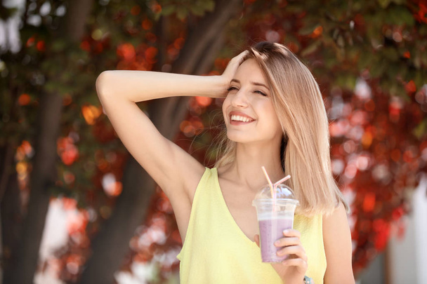 Young woman with plastic cup of healthy smoothie outdoors - Fotografie, Obrázek