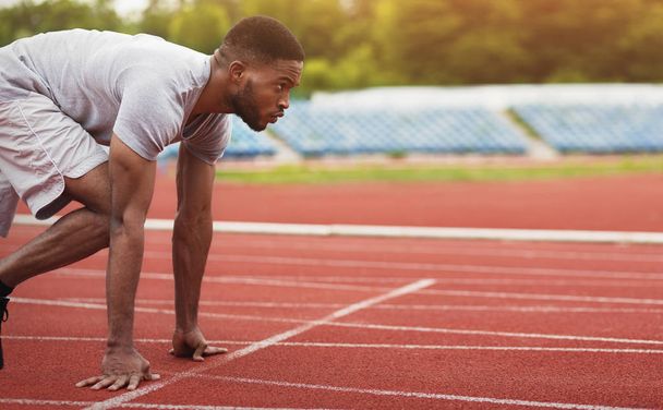 Deportista afroamericano listo para correr en pista de estadio
 - Foto, Imagen