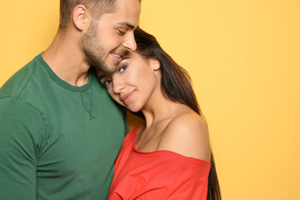 Young happy couple in trendy clothes on yellow background - Foto, Bild