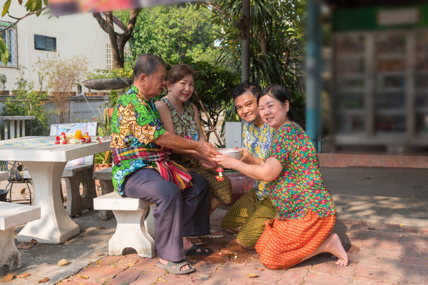 Asiático jovem banho com respeito aos pais pela água tem um jasmim e rosa flor e aromaterapia na água em tigela de água em Songkran Festival
 - Foto, Imagem