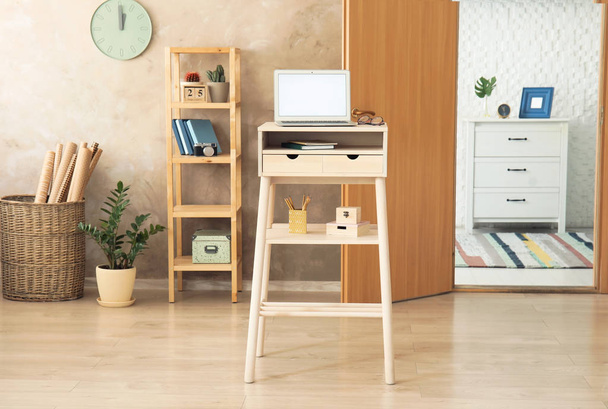 High wooden table with laptop as stand up workplace in modern interior - Фото, зображення
