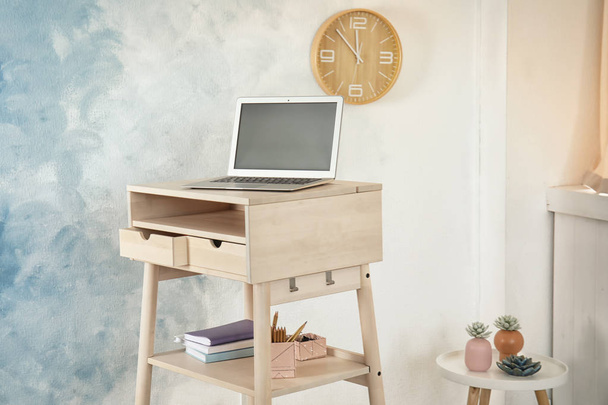 High wooden table with laptop as stand up workplace in modern interior - 写真・画像