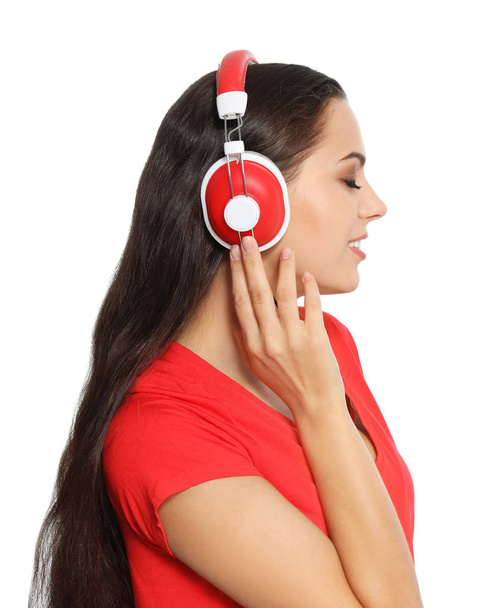 Young woman listening to Christmas music on white background - Foto, Bild