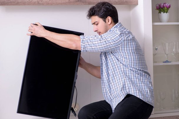 Hombre reparar roto tv en casa - Foto, imagen