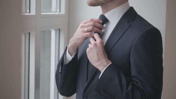 Man in black suit tying tie, groom, businessman concept - Materiaali, video