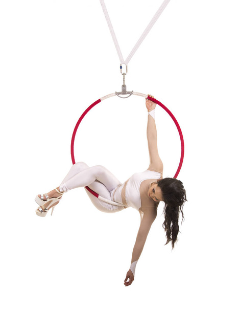 A young girl performs the acrobatic elements in the air ring. Studio shooting performances on a white background. - Фото, изображение