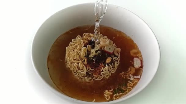 Slow motion Pour warm water in een instant noodle in witte kom is fastfood en ongezond voedsel of vet concept - Video