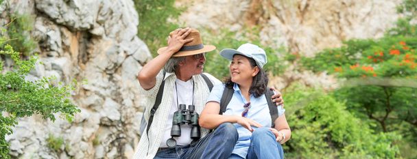Banner of senior couple travel on a summer vacation.they are holding hands and hiking together. - Фото, зображення