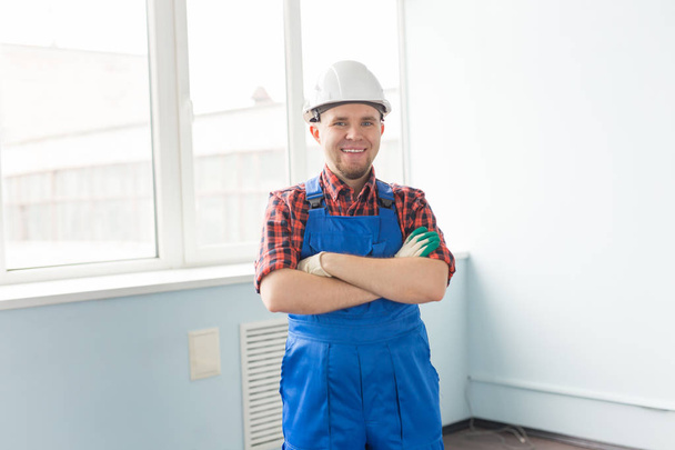 Onnellinen valkoihoinen mies rakentaja ristissä kädet yllään valkoinen kypärä
 - Valokuva, kuva