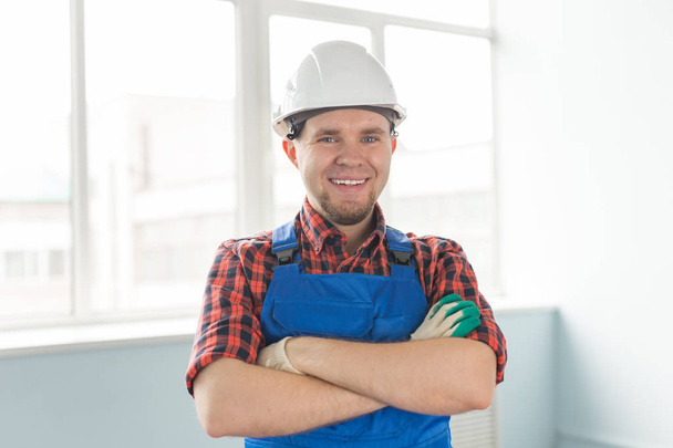 Closeup portrait of happy caucasian male builder wearing white helmet. - 写真・画像