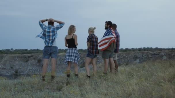 Traveling friends with flag on cliff - Footage, Video