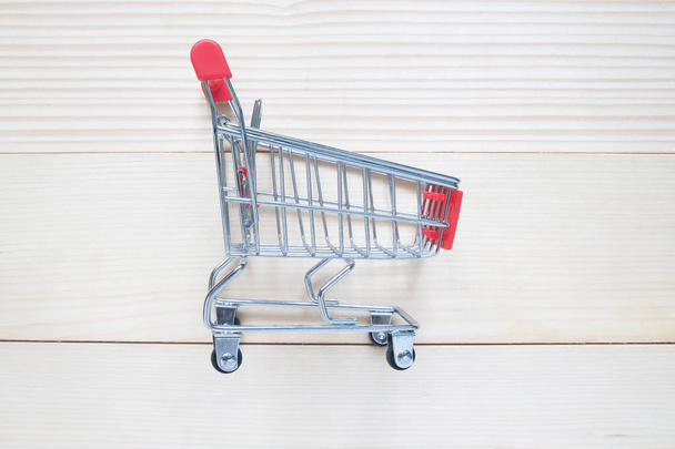 Shopping cart or trolley on wooden background, Shopping concept  - Photo, Image