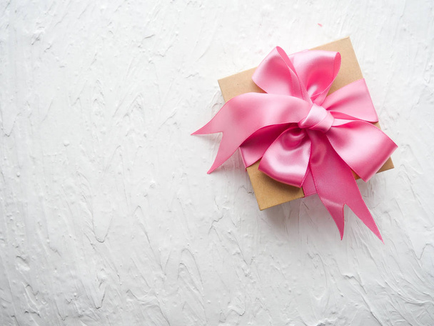 ピンクのリボンが白い背景上に本物の内装のかわいいギフト セットをプレゼント - 写真・画像