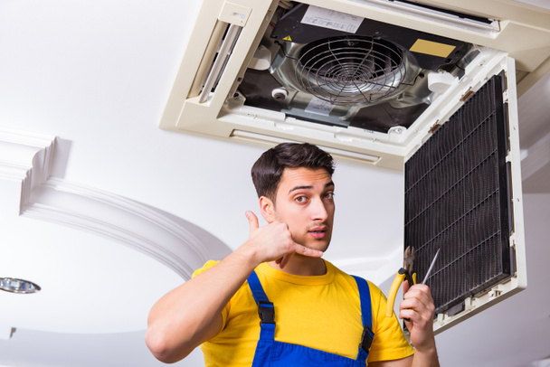 Repairman repairing ceiling air conditioning unit - Photo, Image