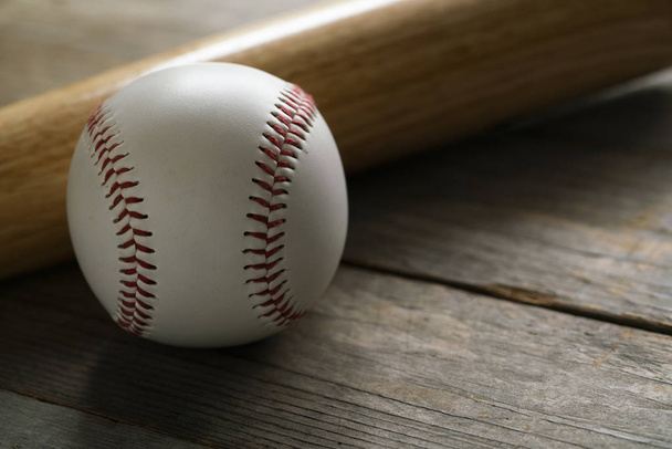 baseball and baseball bat on wooden table background, close up - Foto, immagini