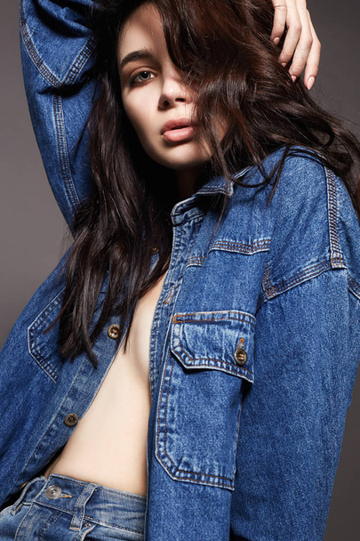 Young brunette woman in jeans. Fashionable Beautiful Sexy Girl - 写真・画像