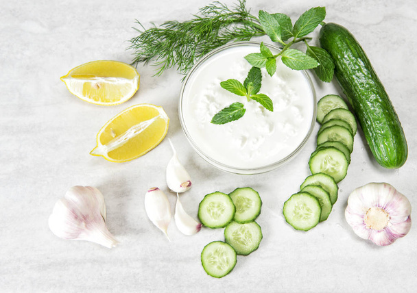 Tzatziki sauce with ingredients cucumber, garlic, dill, lemon, mint. Healthy food - Zdjęcie, obraz