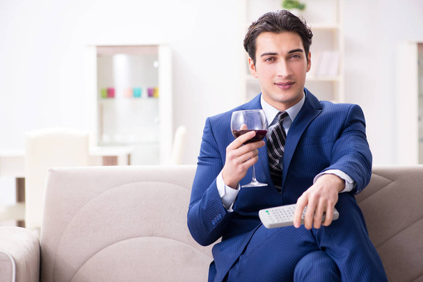 Empresario bebiendo vino sentado en casa - Foto, imagen