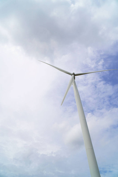 Tuuliturbiinit, jotka tuottavat sähköä sinisen taivaan taustalla.
 . - Valokuva, kuva