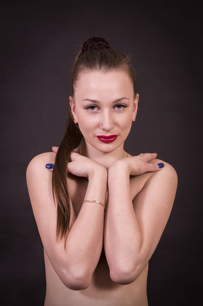 Portrait of brunette, Topless, with makeup and long hair on dark background. Studio shot on a dark background. - Fotó, kép