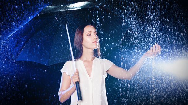 Young woman under umbrella. Protection from rain. - 写真・画像