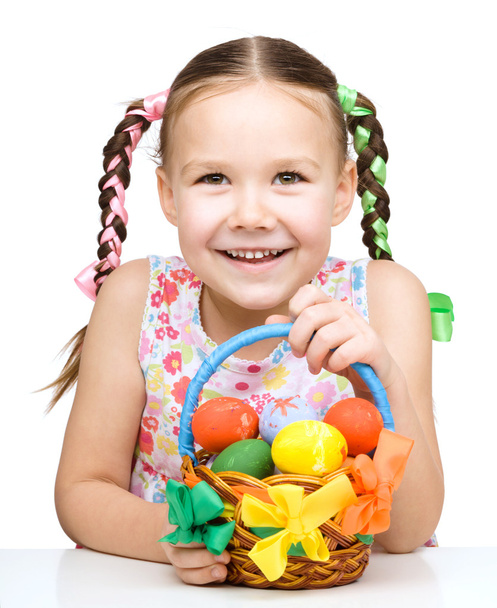 Little girl with basket full of colorful eggs - Foto, Imagen