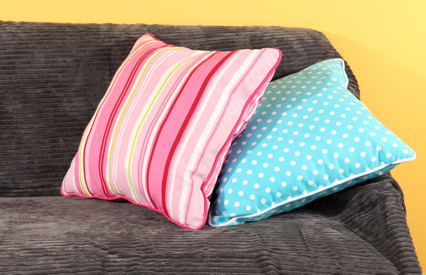 Colorful pillows on couch on yellow background - Φωτογραφία, εικόνα