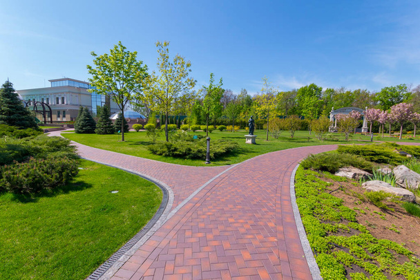 Luxurious park with trimmed lawn and stone paved paths - Photo, Image