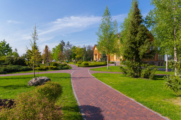 Парк є пішохідна зона з красивих зелених насаджень і шляхи ведуть до величезних дерев'яного будинку. Mezhigorye, Україна - Фото, зображення