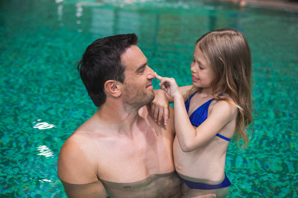 Parent and child enjoying swimming together - Valokuva, kuva