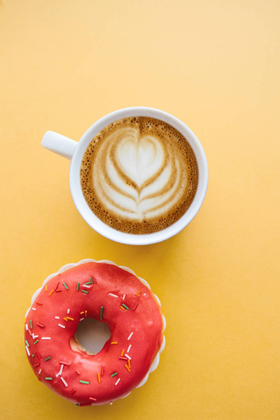 Донька поруч з чашкою ароматної кави або капучино на жовтому фоні
 - Фото, зображення