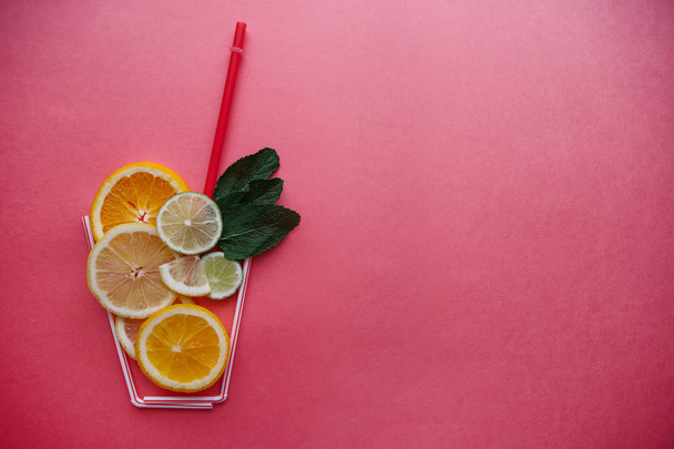 Conceptual photography. Citrus lemonade or juice from fresh fruits in a glass of tubules - Foto, imagen