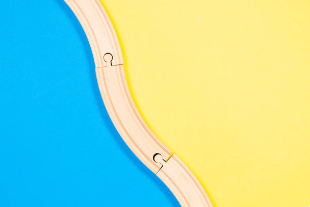 Speelgoed achtergrond. Houten kromme spoorwegen op kleurrijke achtergrond - Foto, afbeelding