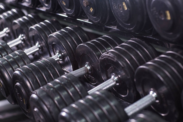 Black dumbbell set in sport fitness center. Weight Training Equipment concept. - Photo, Image