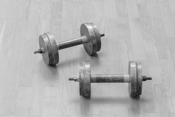 Two iron dumbbells on the floor. the concept of a healthy lifestyle and sport. - Photo, Image