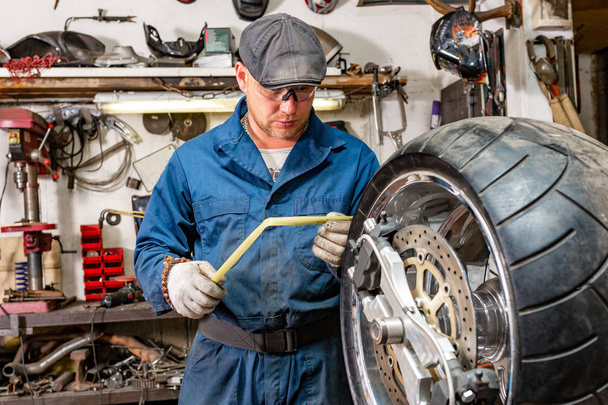 чоловік ремонтує мотоциклетні шини з ремонтом, комплект для ремонту шин для безкамерних шин
. - Фото, зображення