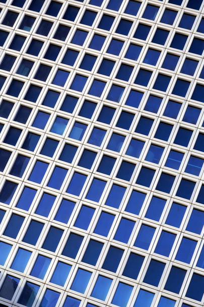 Gebouw gevel detail patroon met vierkante en rechthoekige ramen, moderne stedelijke detail met een perspectief - Foto, afbeelding