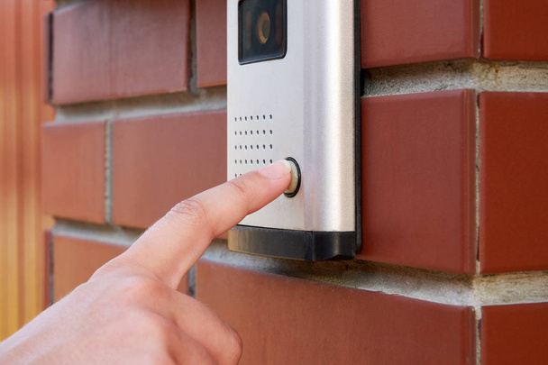 The female hand presses a button doorbell with camera and intercom - Photo, Image