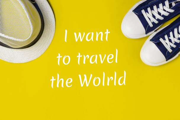 New sneakers and a new hat on a bright background and the inscription I want to travel the world. Top view. The concept of vacations, bright impressions from unforgettable travels - Photo, Image