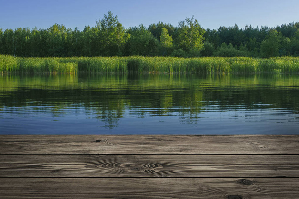 Wooden table from boards on landscape of lake background - Fotó, kép