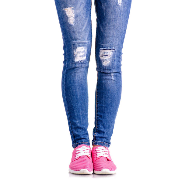 Woman's legs blue denim pink sneakers - Photo, image