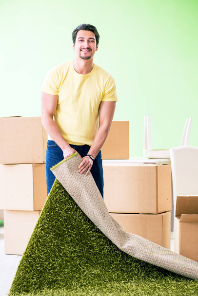 Joven hombre guapo mudándose a casa nueva con cajas - Foto, imagen