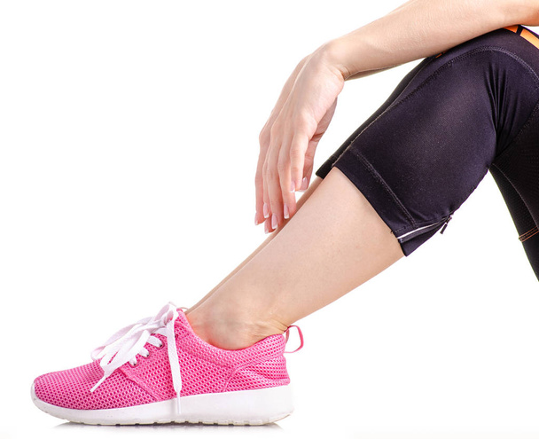 Female legs sports leggings sneakers sports exercises - Foto, afbeelding