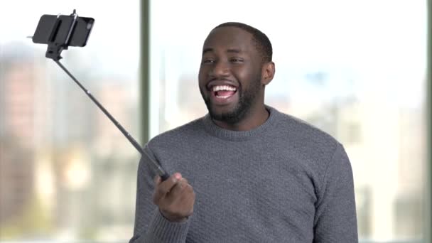 Zwarte Afrikaanse man nemen selfie via selfie stick. - Video