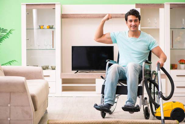 Homme handicapé en fauteuil roulant maison d'aspirateur - Photo, image