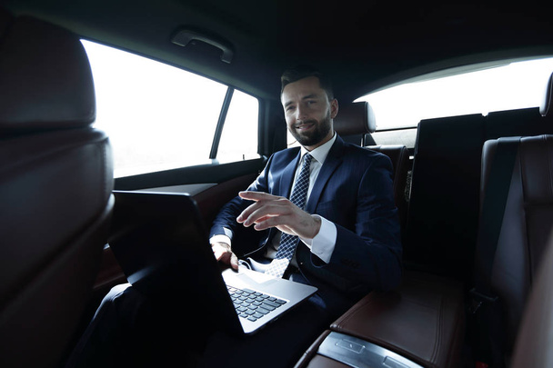 businessman sitting in the back seat in the car and pointing his finger forward - Foto, Imagem