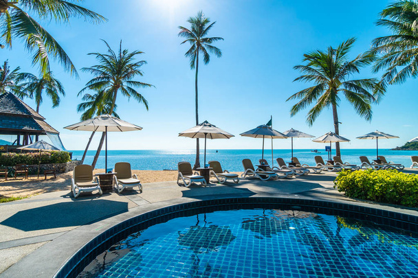 Bela praia tropical e mar com guarda-chuva e cadeira em torno da piscina no resort do hotel para viagens e férias - Foto, Imagem